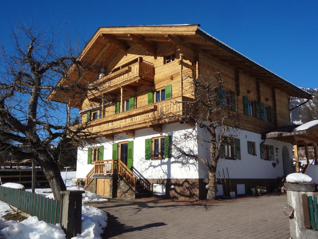 a wooden house with a balcony on top of it at Haus Sonnegg in Fieberbrunn