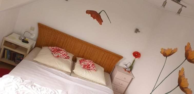 Schlafzimmer mit einem Bett mit roten und weißen Kissen in der Unterkunft Kuća za odmor Voćak in Gornja Voća
