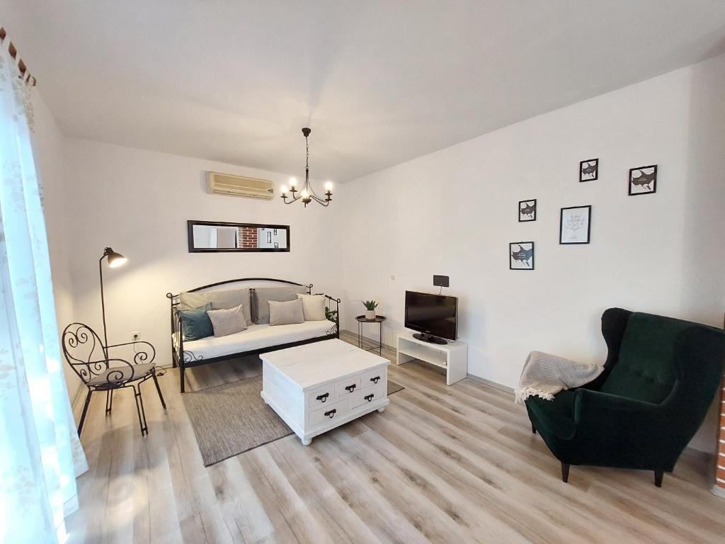 a living room with a bed and a couch and a tv at Villa Blatina in Gradac
