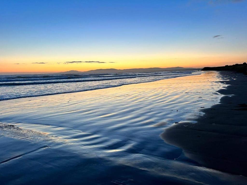 vista para a praia ao pôr-do-sol em Beach House em Donegal