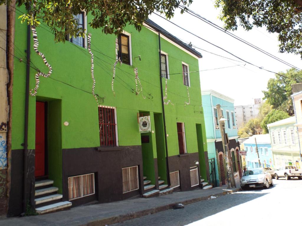 un bâtiment vert sur le côté d'une rue dans l'établissement Hostal Casa Verde Limón, à Valparaíso