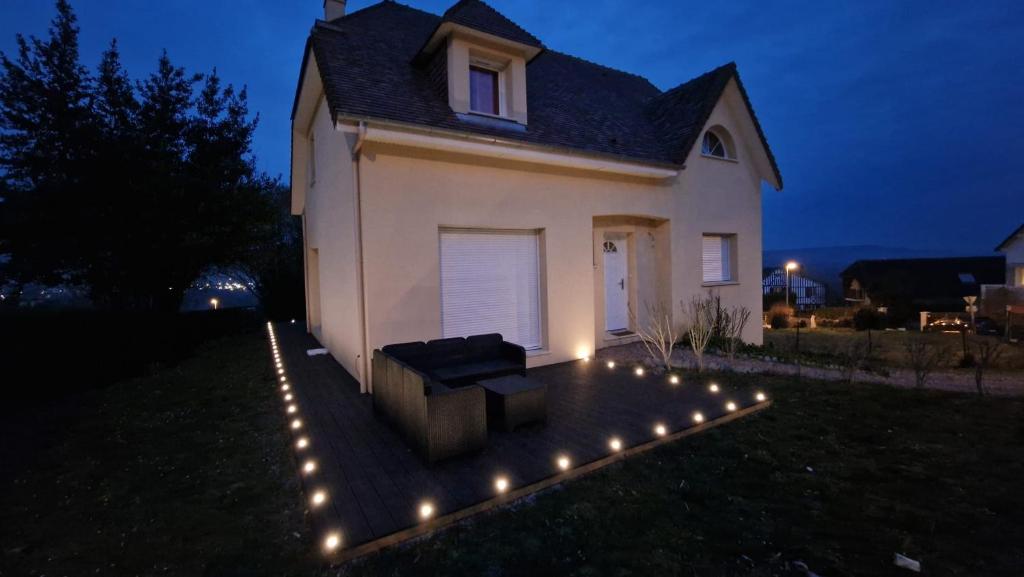 uma casa branca com luzes no quintal à noite em Chez Mado em Deauville