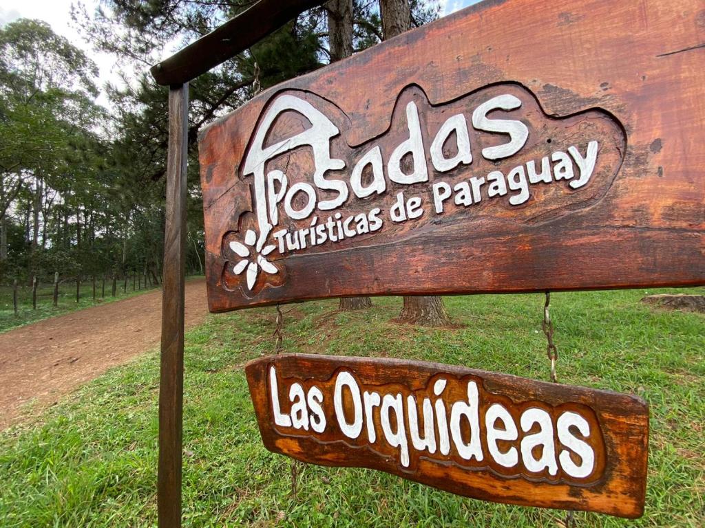 ein Schild für einen Park mit zwei Schildern darauf in der Unterkunft Posada Turística Las Orquídeas in Cambyretá