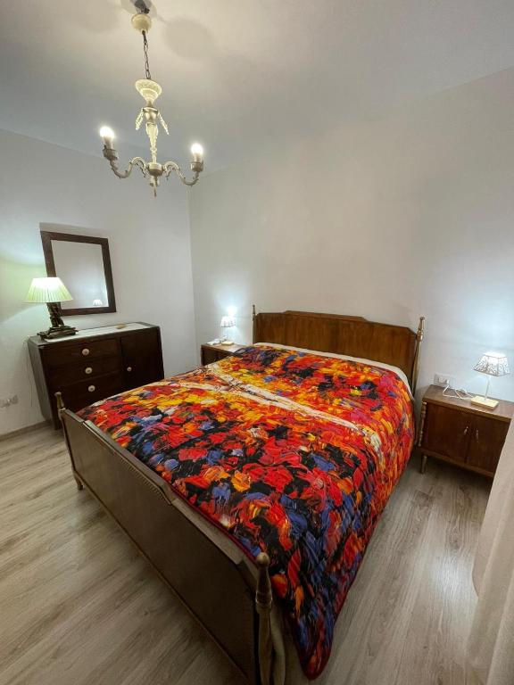 Un dormitorio con una cama con una colcha colorida. en Savonarola 45_Casa completa nel centro storico, en Latronico