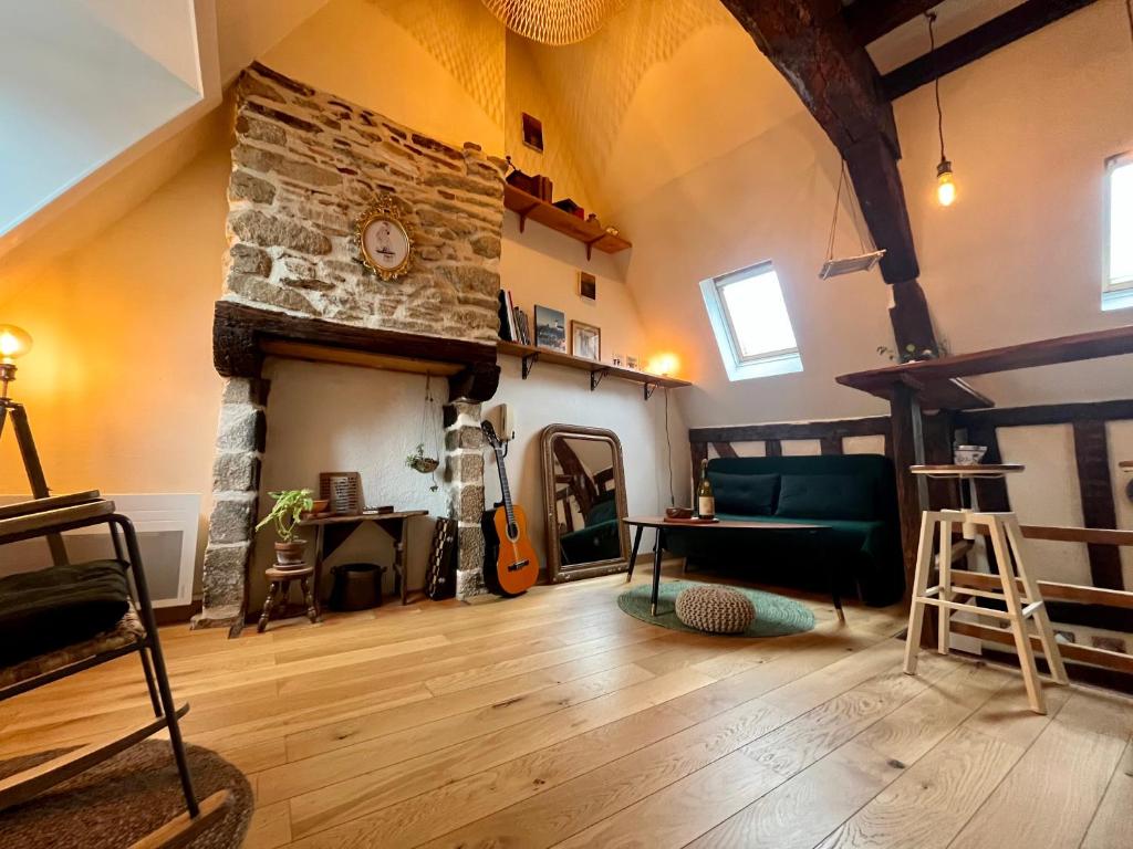 a living room with a stone fireplace and a couch at Bienvenue à Indra in Vannes