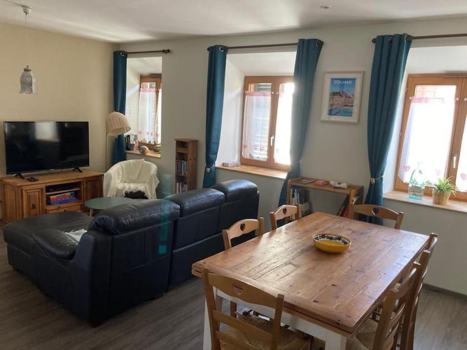 a living room with a couch and a table at Logement chaleureux, vallée de Villé in Steige