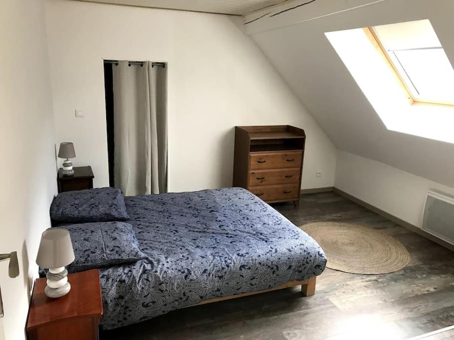 sypialnia z łóżkiem, komodą i oknem w obiekcie Logement chaleureux, vallée de Villé w mieście Steige