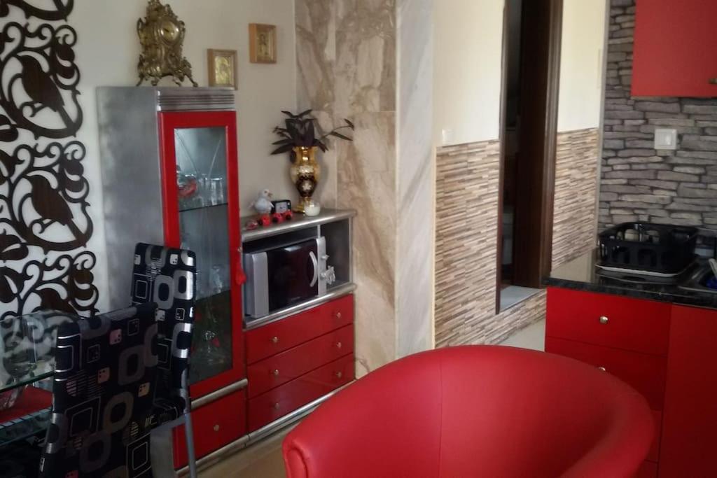 Habitación con silla roja y armario rojo. en Sofaki Apartments en Tesalónica