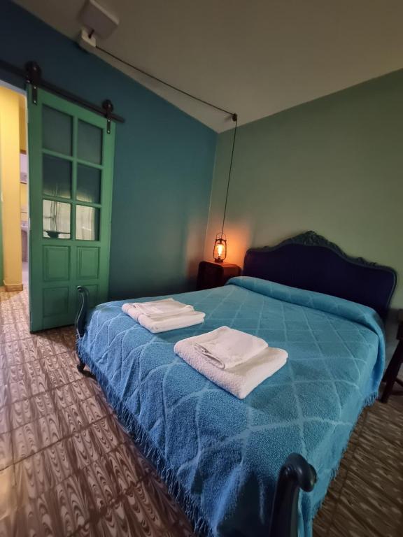 una camera da letto con un letto blu e asciugamani di Acogedora suite con ingreso independiente. a Jesús María