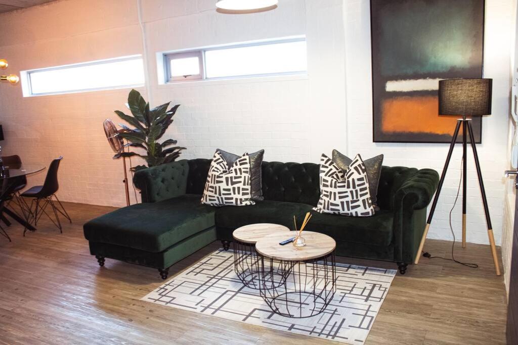 sala de estar con sofá verde y mesa en Coco Swift No.4, en Ciudad del Cabo