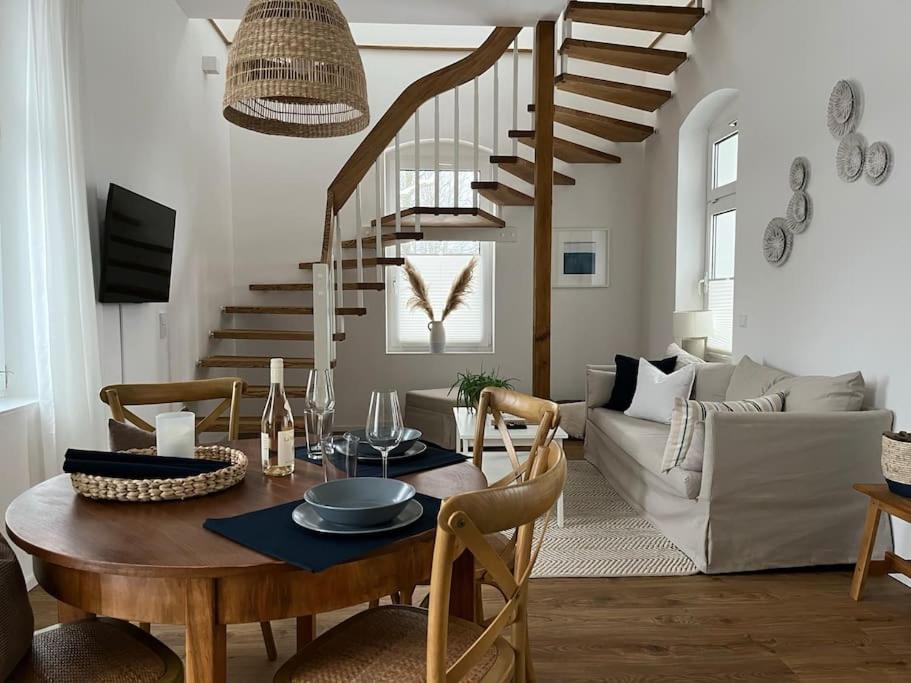 ein Wohnzimmer mit einem Tisch und einer Treppe in der Unterkunft Wohlfühl-Apartment am Paradiesberg in Radebeul