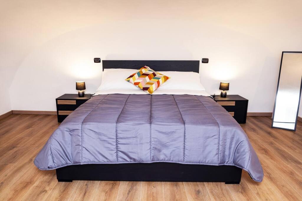 um quarto com uma grande cama roxa com duas mesas de cabeceira em Artisti Home Naples em Nápoles
