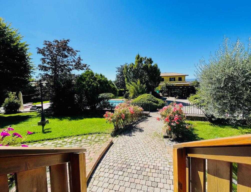 un jardín con flores y una pasarela con valla en Chalet San Martino, en San Martino in Colle