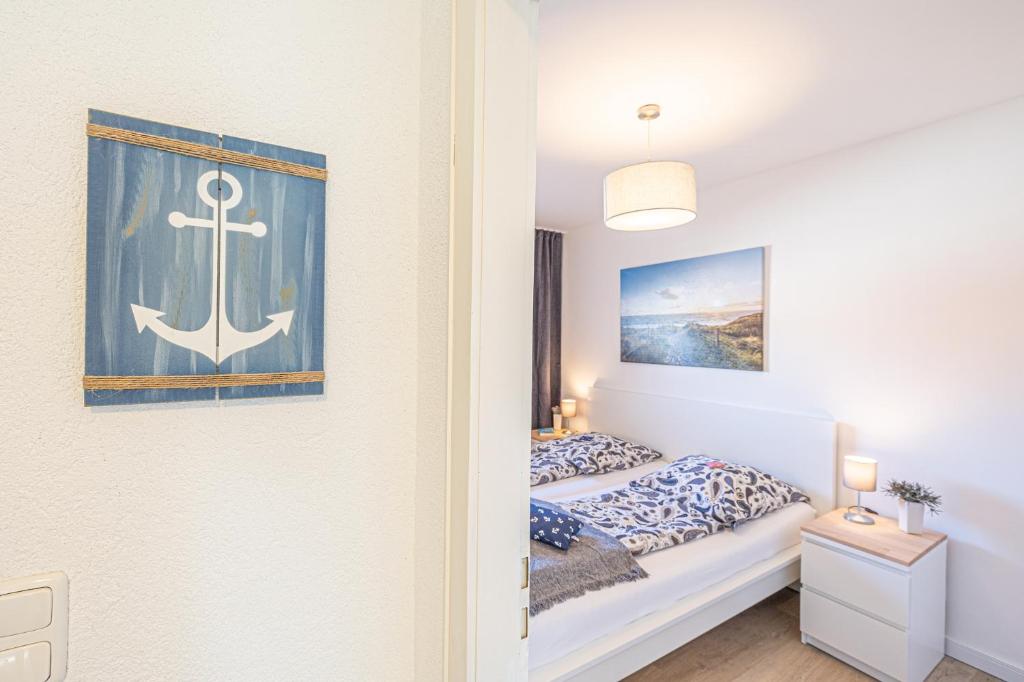 ein Schlafzimmer mit einem Bett mit einem Anker an der Wand in der Unterkunft Ferienwohnungen im Haus Strandburg Grömitz in Grömitz