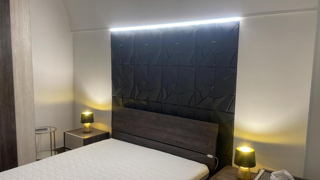 Un dormitorio con una cama con dos luces. en B&B Nami, en Palagianello