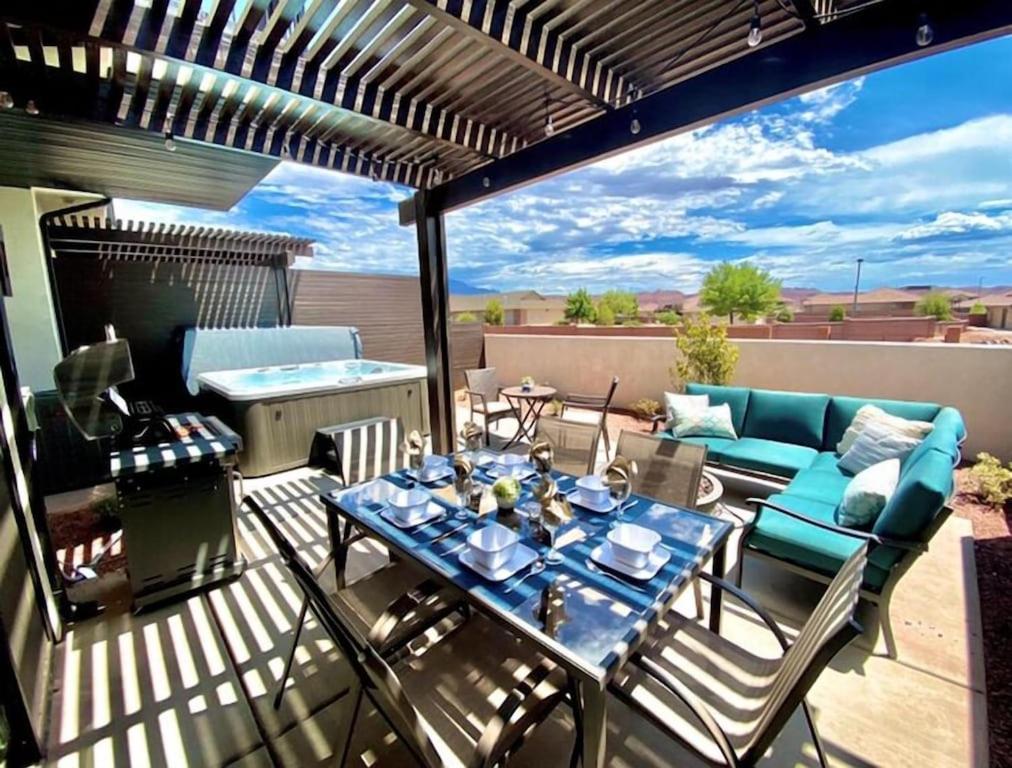 a patio with a table and a couch on a deck at Ocotillo 69 3 Bedrooms with a Private Hot Tub, Fire Pit, and Private Patio in Santa Clara