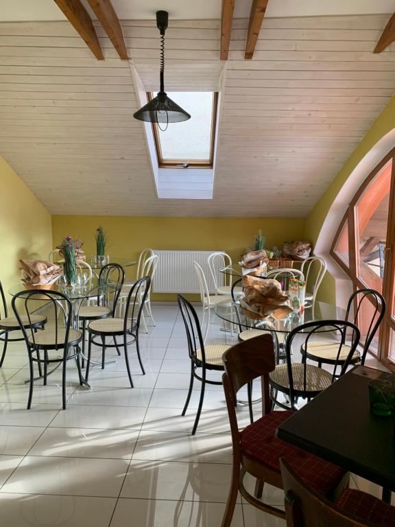 a dining room with tables and chairs and a ceiling at Penzión Rosenau in Rožňava