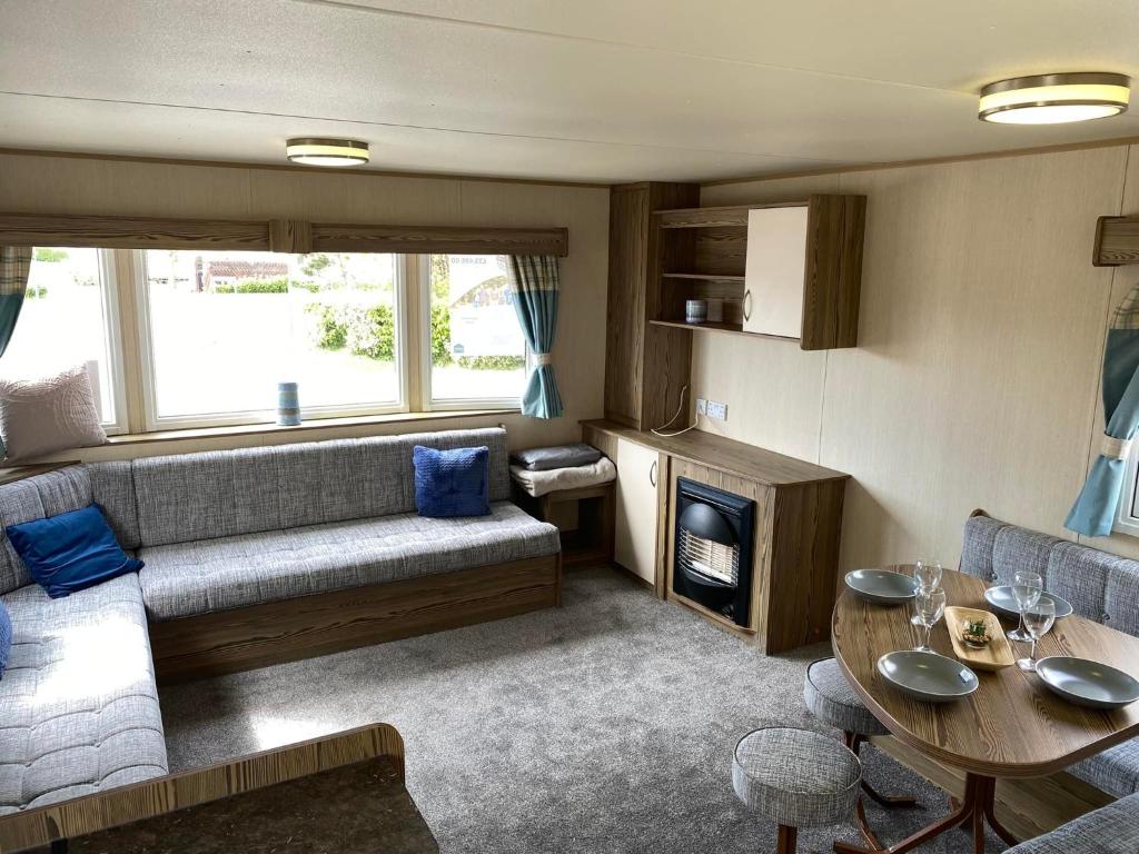 a living room with a couch and a table at Withersea Sand Holiday Home in Withernsea