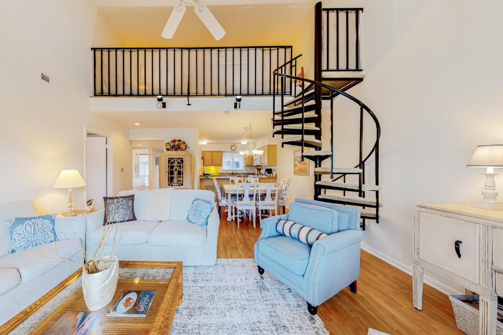 a living room with a couch and a spiral staircase at Sea Colony --- 2305 Round Robin Way in Bethany Beach