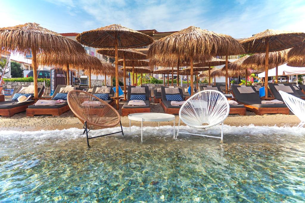 un gruppo di sedie e ombrelloni in spiaggia di Hotel Odysseas a Polykhrono