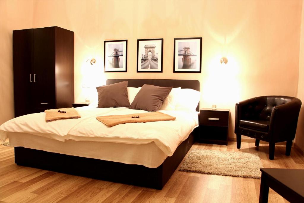 a bedroom with a large bed and a black chair at Budapest Ville Bed & Breakfast in Budapest
