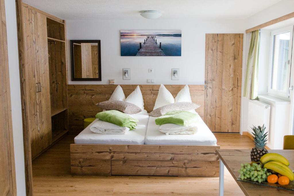 een slaapkamer met een houten bed met kussens erop bij Haidegger Appartements in Innsbruck