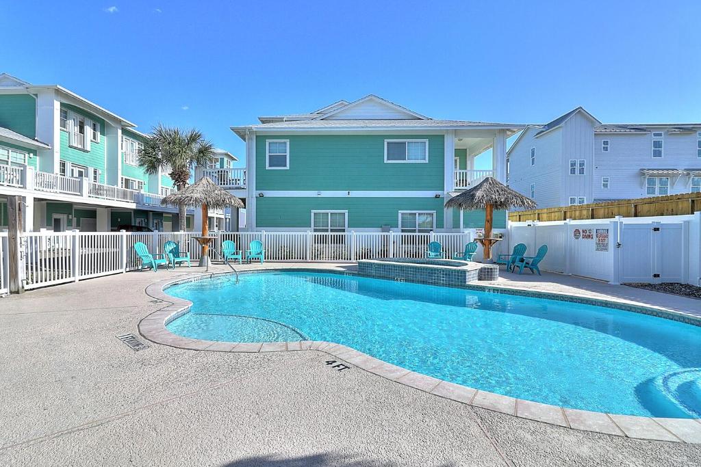 a swimming pool in front of a house at Barefoot Retreat MC15 in Port Aransas