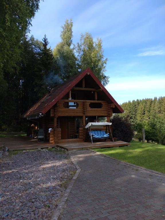 uma cabana de madeira com fumo a sair dela em Saunaga külalistemaja, Tartust 9km kaugusel 