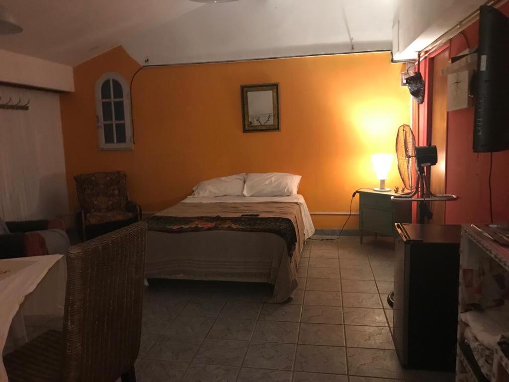 um quarto com uma cama com uma parede laranja em Soul Habitaciones em Ezeiza