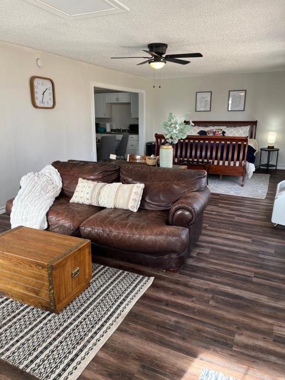 sala de estar con sofá de cuero marrón en The Airstream Lodge, en Lubbock