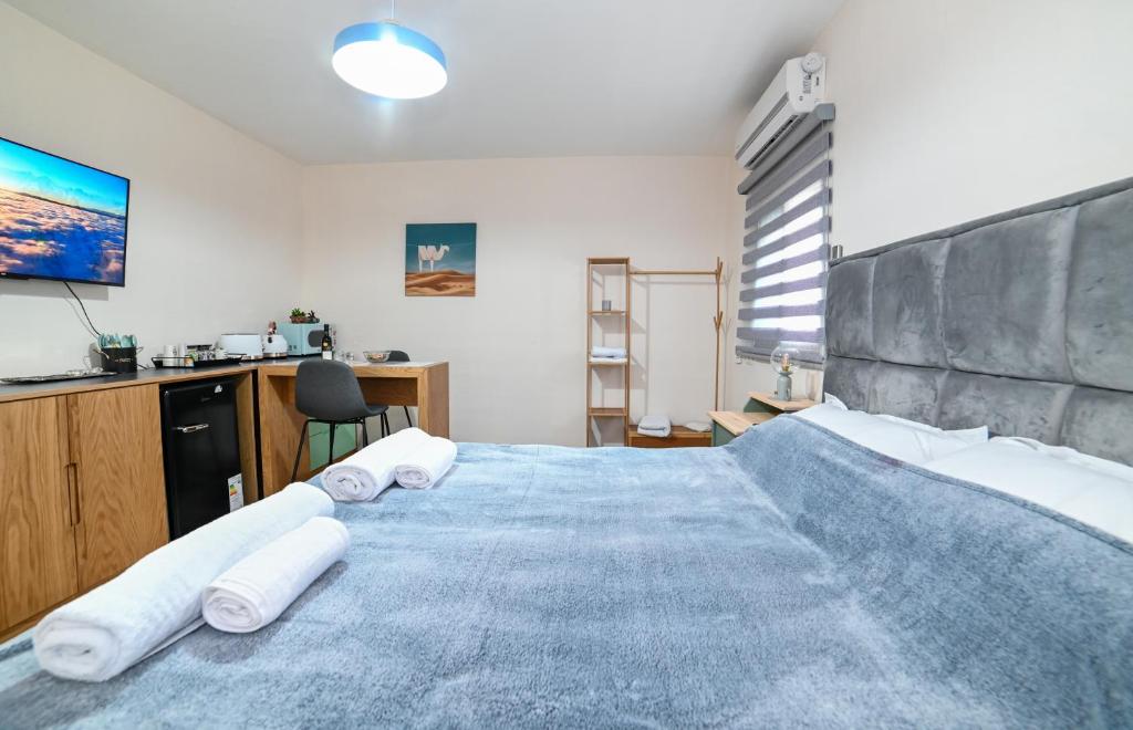 1 dormitorio con 1 cama grande y toallas. en The Turquoise House, en Poriyya