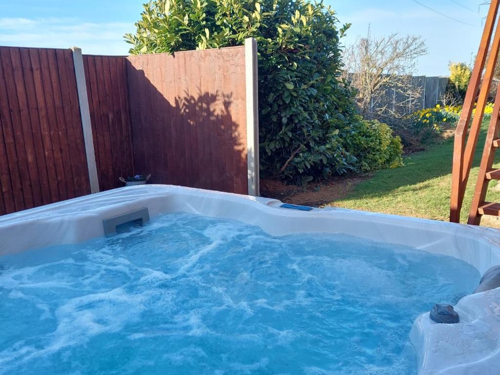 a hot tub with blue water in a backyard at The Viewpoint in Deal