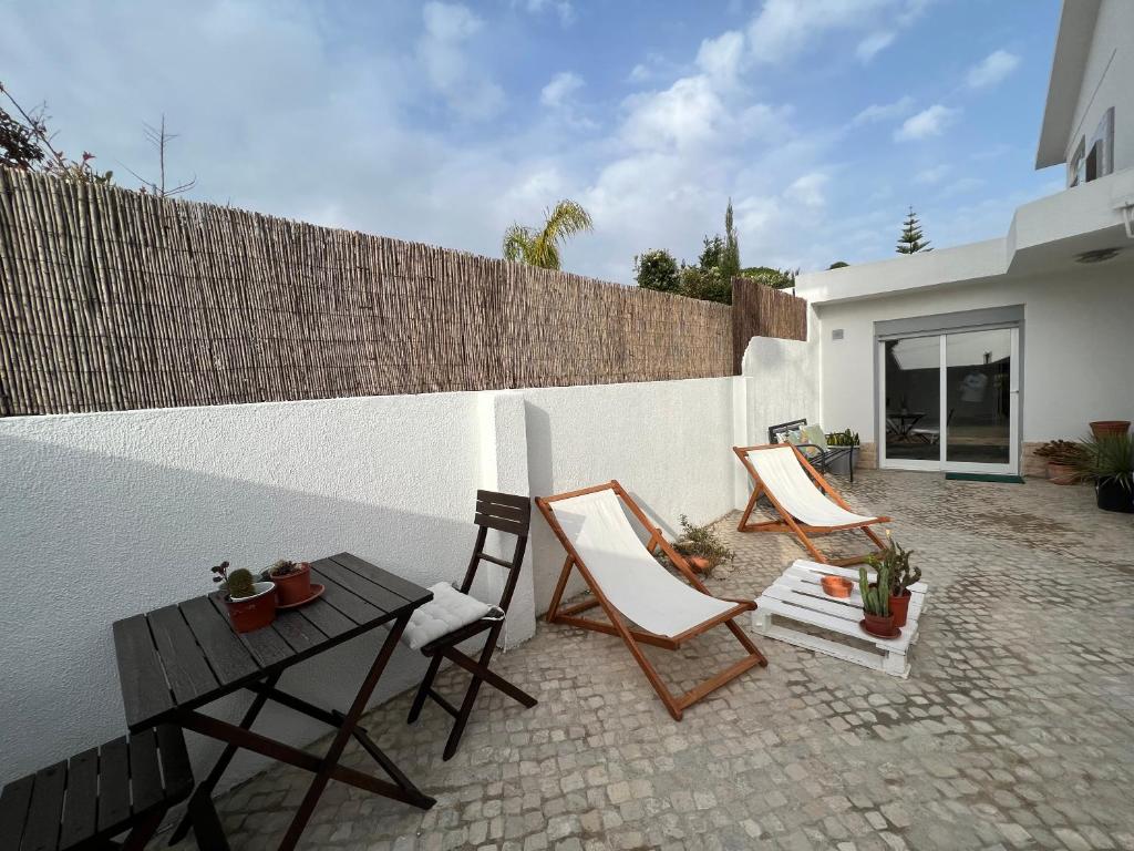 a patio with chairs and a table and a fence at IN-Cascais Suite Deluxe com pátio privado in Cascais
