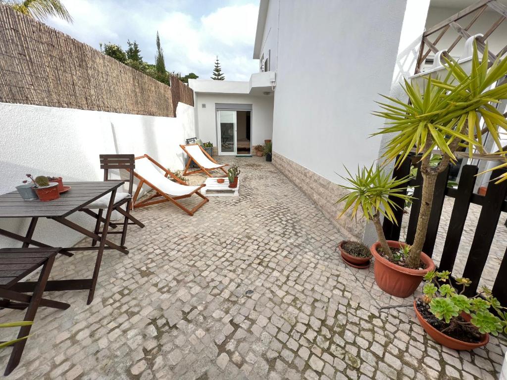 a patio with a table and chairs and potted plants at IN-Cascais Suite Deluxe com pátio privado in Cascais
