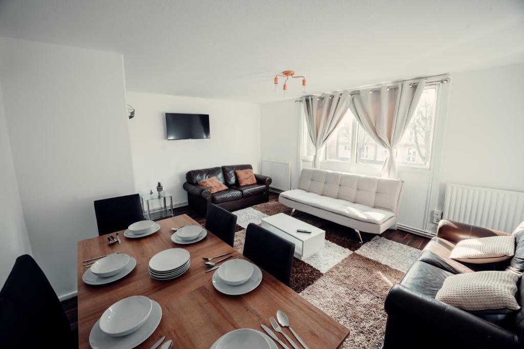 a living room with a table and a couch at Comfy Home-Wood Green in London