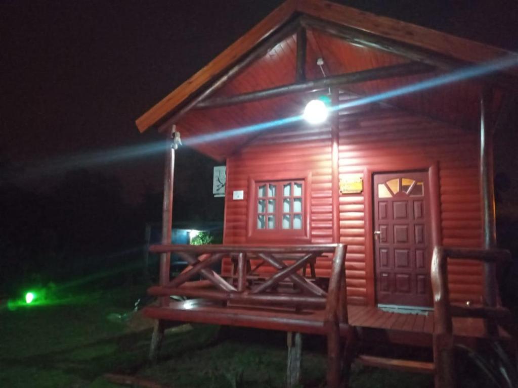 una pequeña cabaña de madera con una luz encendida por la noche en La Beatriz en San José