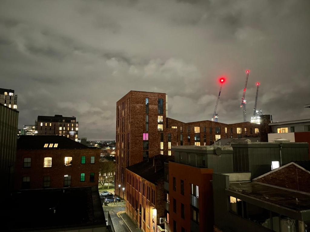 a view of a city with buildings and a red light at City centre apartment in Manchester