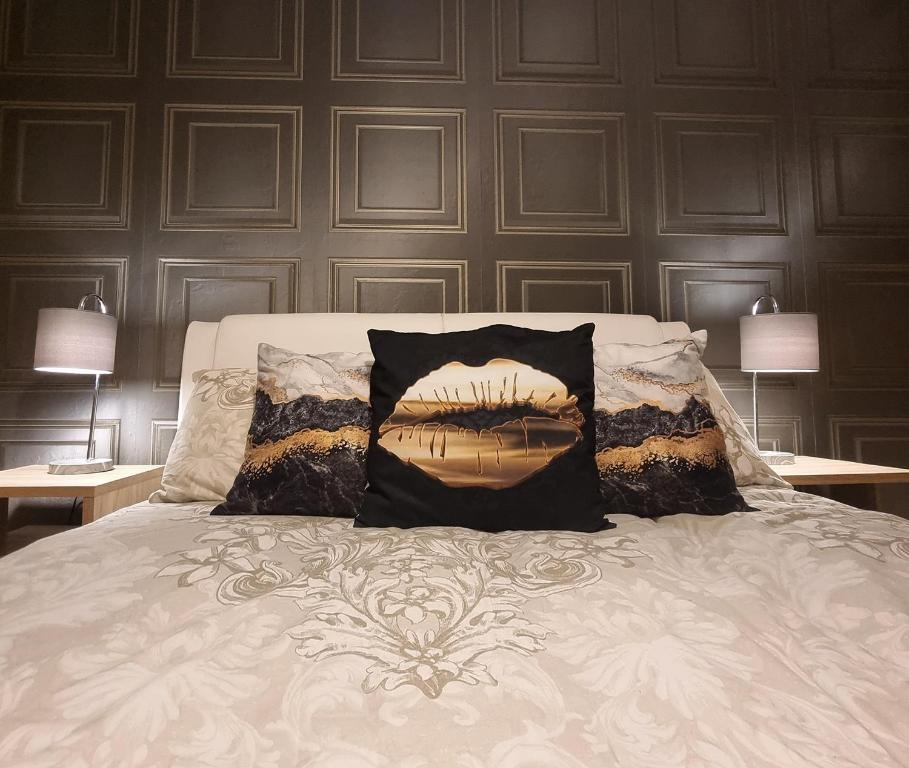 a bed with two pillows on it with two lamps at Spacious house City skyline and mountain views close too belfast centre and airports free parking in Belfast