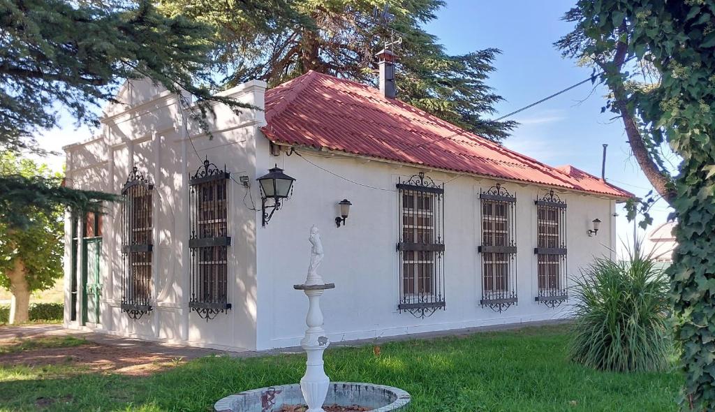 uma casa branca com um telhado vermelho e uma fonte em Casa de Campo Finca La Superiora em La Consulta