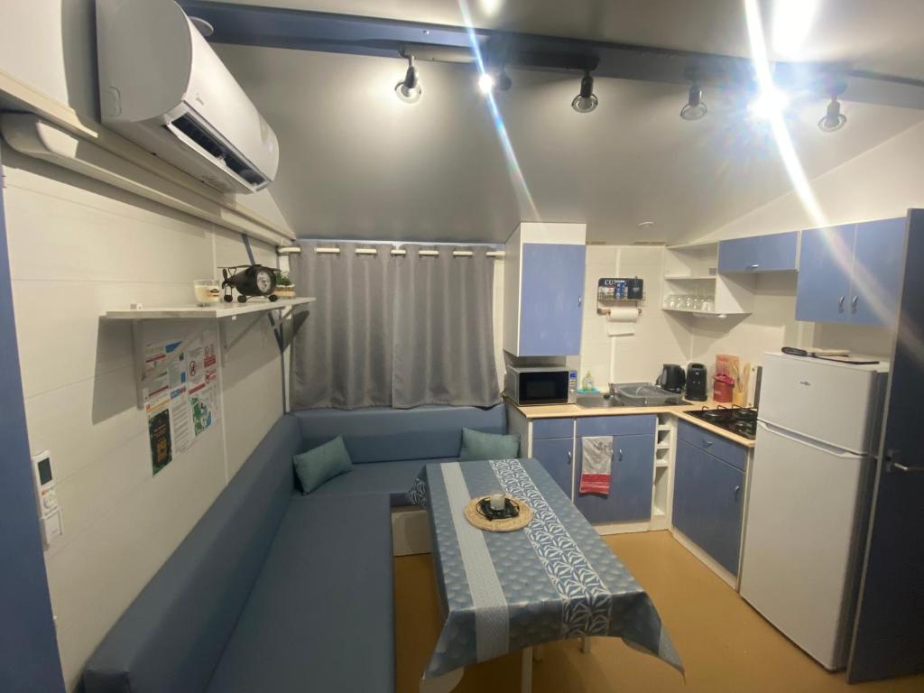 une petite cuisine avec une table au milieu dans l'établissement Bungalow 2/4 personnes dans résidence Hôtelière, à Meyzieu