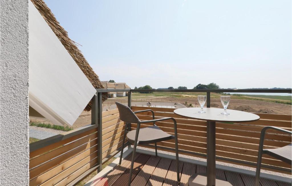 een balkon met een tafel en stoelen en uitzicht op het strand bij Fewo 8 Putbus-rgen in Wreechen