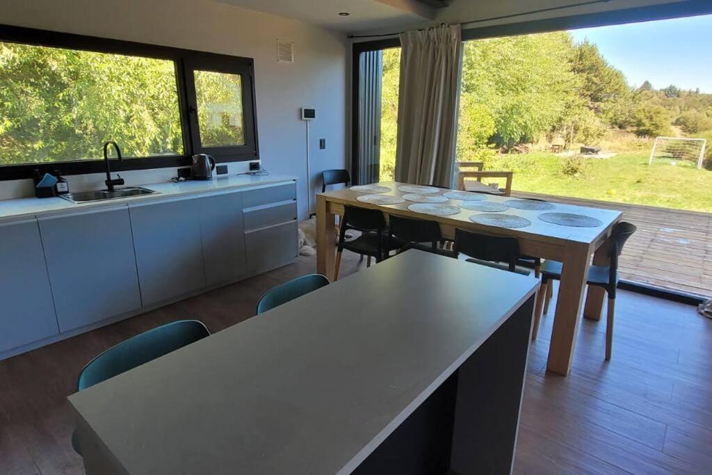 cocina con 2 mesas y cocina con vistas en Paihuen: casa moderna con vista en San Carlos de Bariloche