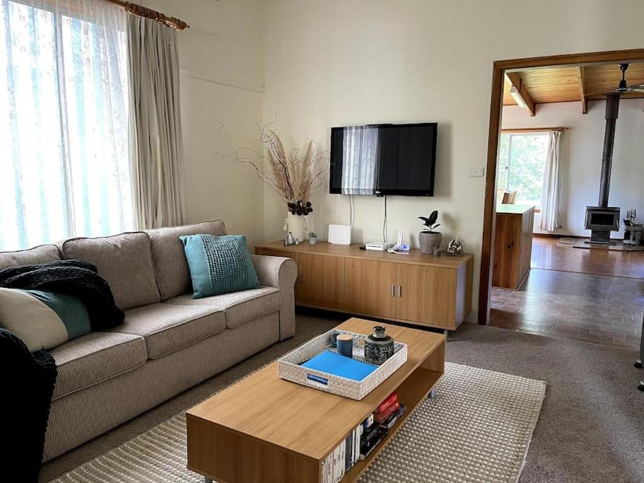 a living room with a couch and a tv at Family cottage with Spa in Cowes