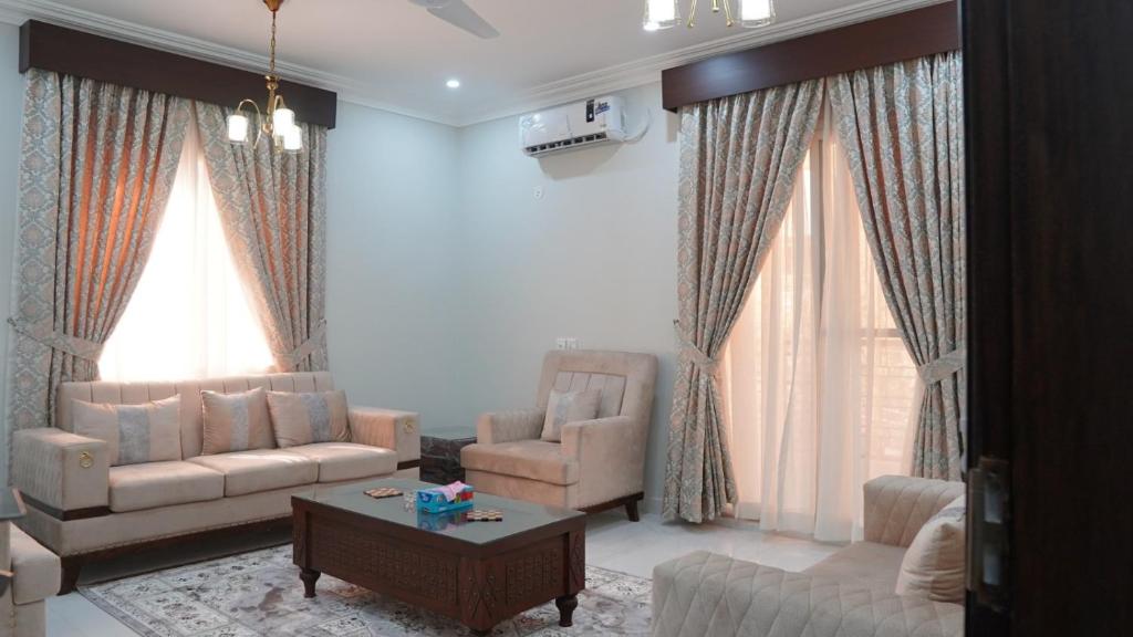 a living room with two couches and a coffee table at Al Rasheed Apartments second floor apartment in Karachi