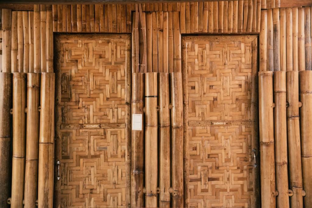 une paire de portes dans un bâtiment en bambou dans l'établissement Loko Amigos Bohol Panglao, à Mormol