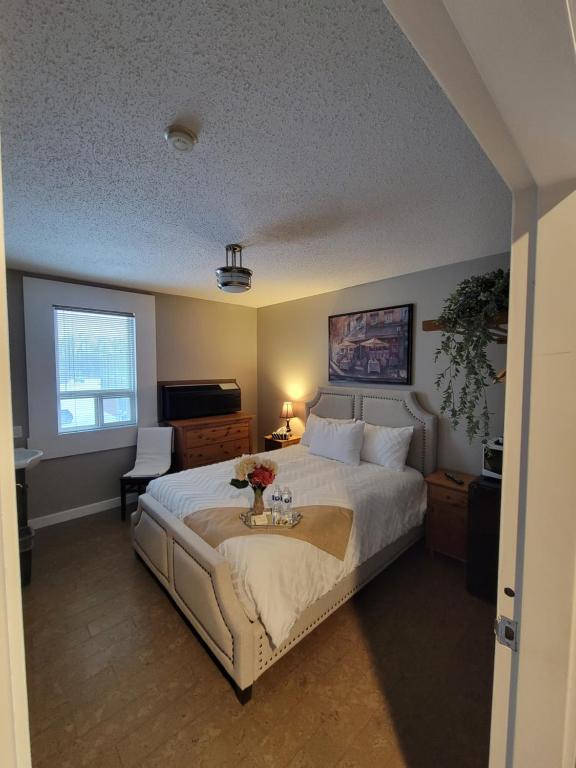 a bedroom with a large white bed and a window at Royal Duke Hotel in Okotoks