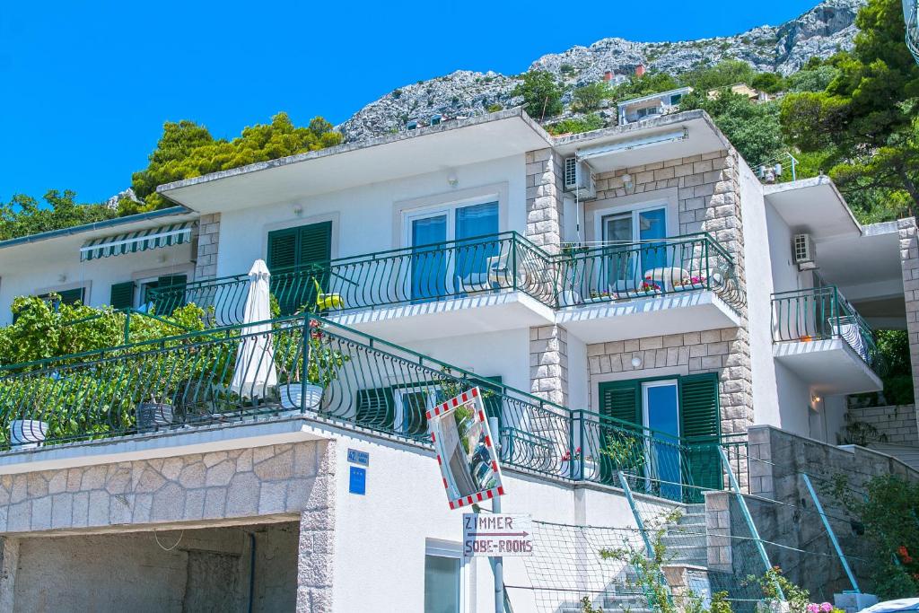 a white building with balconies on a hill at Apartment Brela 16603b in Brela