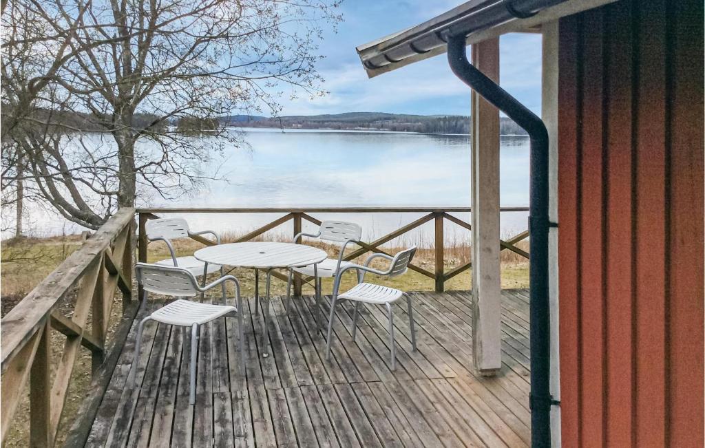 een terras met een tafel en stoelen en uitzicht op een meer bij Stunning Home In Ludvika With Lake View in Ludvika
