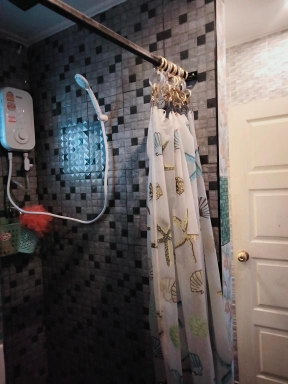 a shower curtain is hanging in a bathroom at บ้านเช่า 