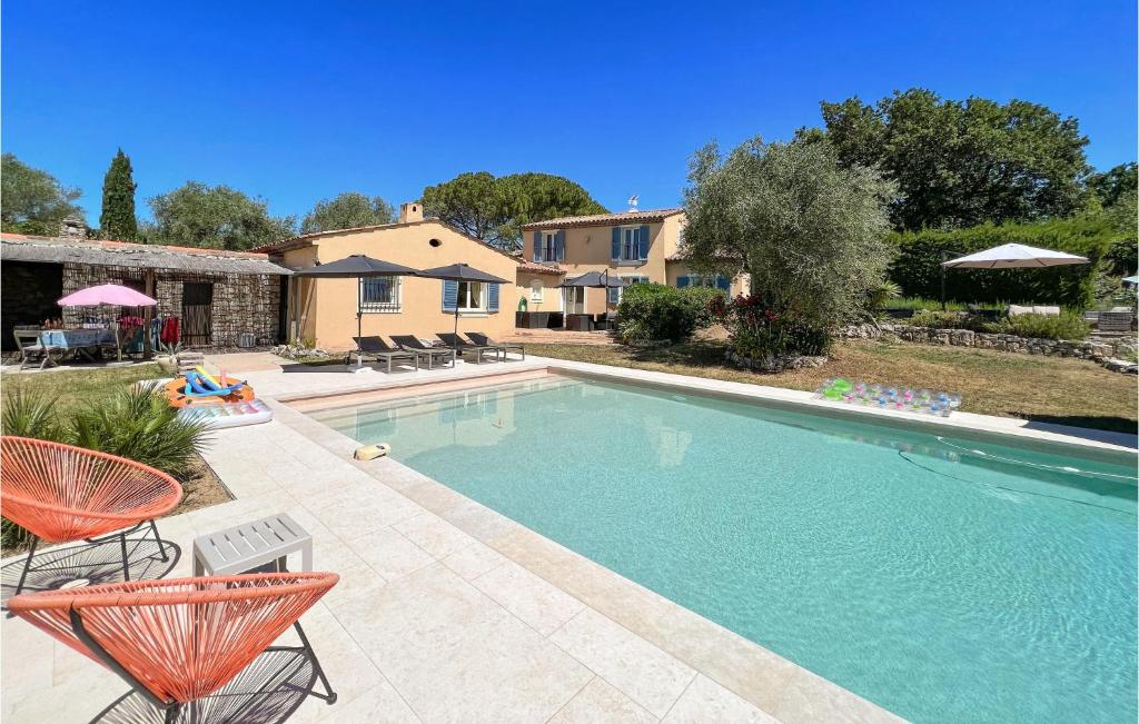 a swimming pool with chairs and a house at Maison Des Rêves in Saint-Cézaire-sur-Siagne